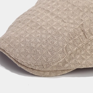 Gros plan du béret beige de style britannique avec texture gaufrée et coutures