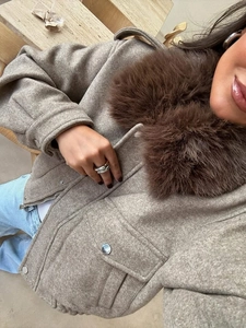 Detail of oatmeal jacket with plush brown faux fur collar and metal zipper hardware