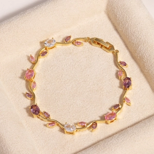 Detail eines vergoldeten Armbands in Rebenform mit rosa, lila und klaren Zirkonia