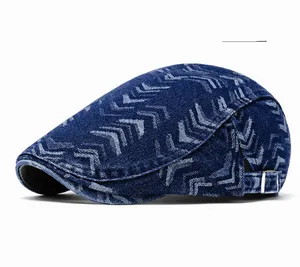 Detail of deep blue denim flat cap with V-shaped arrow pattern and adjustable side buckle