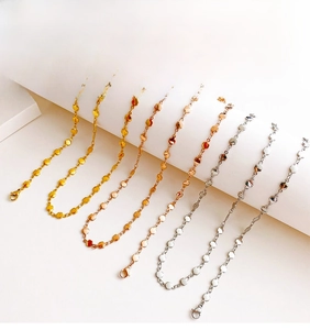Detailed close-up of heart-shaped link chains in gold, rose gold, and silver finishes