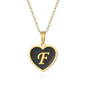Detail of gold heart pendant necklace featuring black enamel inlay and gold letter F engraving
