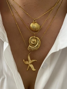Detailed layered gold necklace set featuring starfish and seashell pendant charms