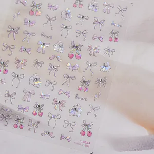 Close-up of glitter crystal nail stickers featuring pink bows and rabbit designs