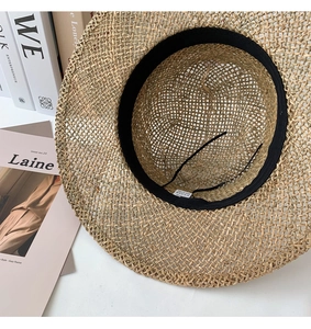 Detailed inner view of woven seagrass sun hat with sweatband and adjustable strap