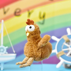 Nahaufnahme eines süßen braunen Plüsch-Küken-Anhängers vor buntem Regenbogenhintergrund