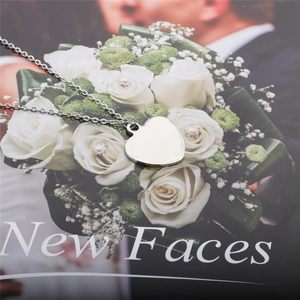 Close-up of a silver heart pendant necklace lying on a romantic magazine background