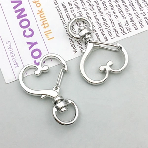 Macro detail of heart-shaped silver lobster clasps for DIY jewelry and keychain making