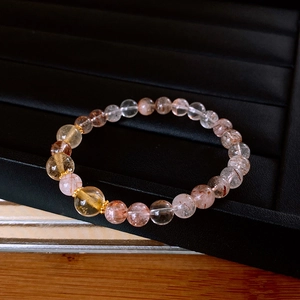 Detailed macro shot of citrine and strawberry quartz beads with gold-tone accents