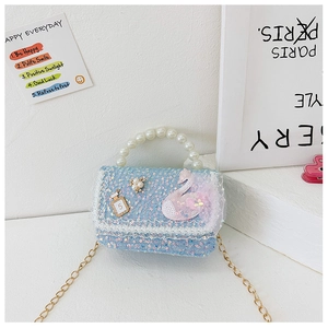 Detail of blue sequin girl handbag with pearl handle, swan patch and lace edge