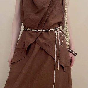 Detail of bohemian hand-woven waist chain with wooden beads on linen dress for women