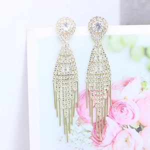 Close-up of elegant gold long tassel earrings with sparkling white crystals for women