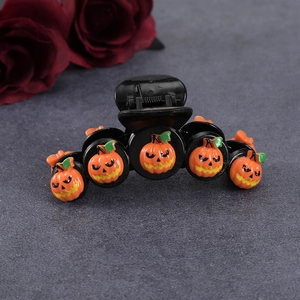 Detail of black hair claw clip with seven unique orange pumpkin charms for Halloween