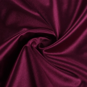 Gros plan du tissu de robe de soirée en satin bordeaux avec texture de soie élégante