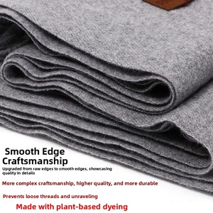 Macro shot of light gray wool cashmere scarf fabric texture and brown leather label