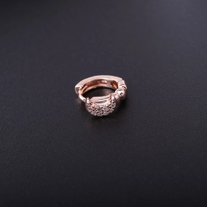 Macro shot of rose gold moon-shaped earring with sparkling zircon inlay details