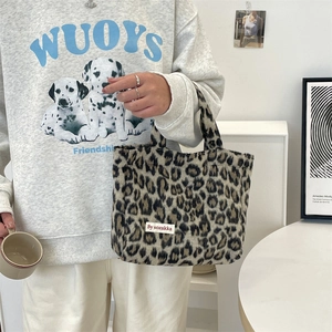 Close-up of leopard print faux fur handbag with branded woven label and soft texture