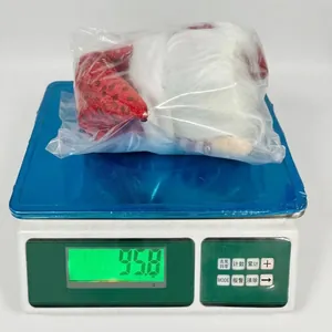 Detailed view of plush Christmas gnome ornaments being weighed for quality control