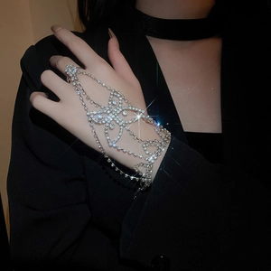Close-up of sparkling butterfly ring-bracelet with rhinestones on a female model