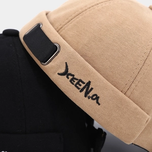 Knitted docker hat with Jeena embroidery and strap detail in khaki and black colors