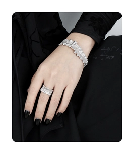 Detailed view of silver pleated cuff bracelet and matching ring on model hand