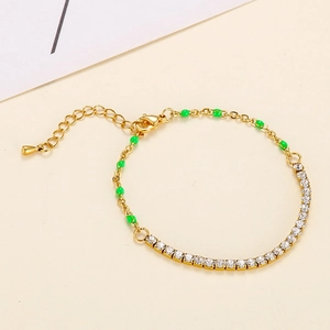 Gold-tone bracelet featuring white rhinestones and green enamel beads with lobster clasp