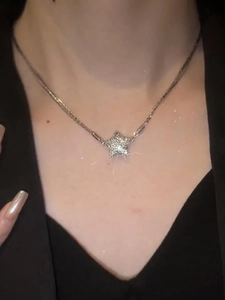 Close-up of sparkling star pendant necklace with magnetic clasp on a model neck