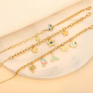 Trois bracelets à breloques dorés avec papillons et étoiles en émail coloré sur plateau