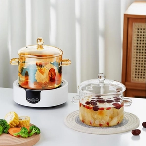 Detail of clear and amber borosilicate glass cooking pots with dual handles and lids
