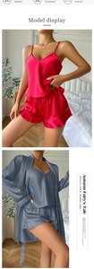 Close-up of pink and blue satin pajama sets featuring lace shorts and silk-like robes