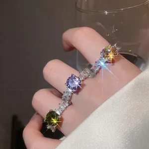 Luxury colorful zircon rings in emerald and purple stones worn on a model's hand