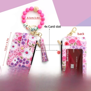 Pink floral card wallet with silicone beaded wristlet and tassel detail close-up