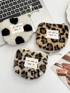 Three plush heart-shaped mini pouches with leopard print and polka dots on white desk