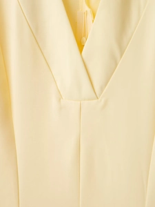 Vista de detalle de vestido amarillo pálido con cuello en V y cremallera invisible lisa