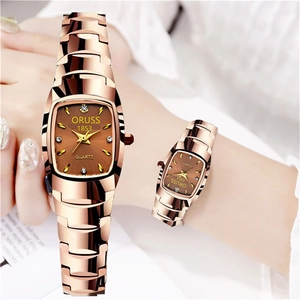 Macro detail of rose gold tonneau-shaped quartz watch dial with crystal indices