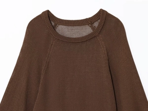 Close-up of the ribbed crew neck and raglan sleeve seams on a brown knit sweater