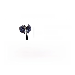 Detail view of retro blue lace bow hair claw with floral pattern and pearl tassel