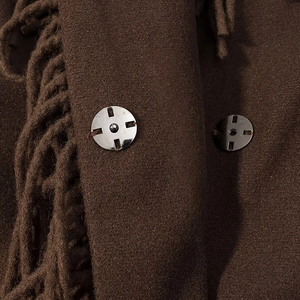 Détails du manteau en laine marron foncé avec bouton métallique et bord frangé