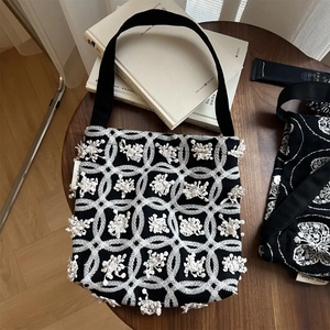 Detail of canvas bag with white circular embroidery and simple wish woven label