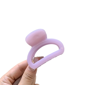 Lavender hollow butterfly hair claw clip held by hand for high ponytail styling