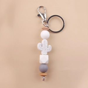 Detail of silicone cactus charm and wooden beads on a white and grey keychain wristlet