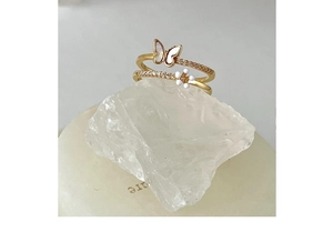Detailed shot of a gold-plated ring with mother of pearl butterfly and floral pearl inlay