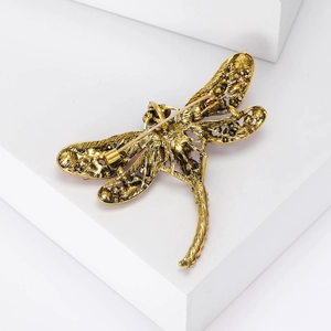 Macro shot showing the metal pin and vintage finish on the back of a gold dragonfly brooch