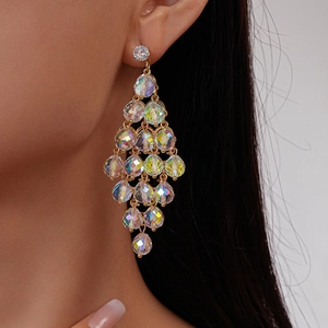 Detail of crystal drop earrings with rainbow luster on gold metal worn by a model