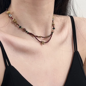 Detail of ethnic beaded double necklace with colorful stones on a model's neck