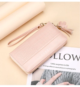 Pink long wallet with crocodile texture featuring flower tassel and wrist strap