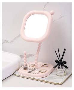 Close-up of pink creamy pearl style makeup mirror with integrated jewelry storage base