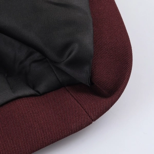 Close-up of wine red tweed jacket with black lining and premium textured stitching details