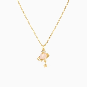 Detail of gold Saturn planet necklace with pink crystal and small star pendant charms