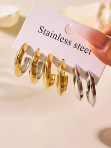 Detailed view of polished C-shaped geometric hoop earrings in gold and silver finish